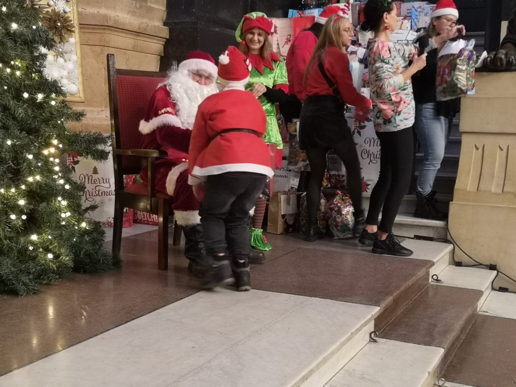 Pani odbiera prezent od Mikolaja.